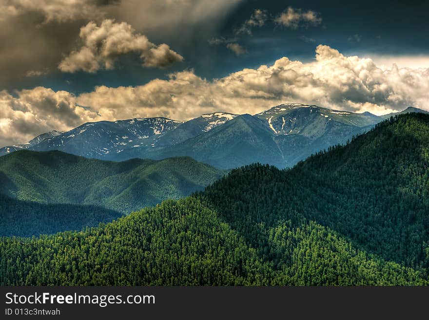 Remote glacier and clouds in mountains