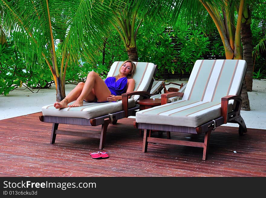 Woman lying on chaise longue