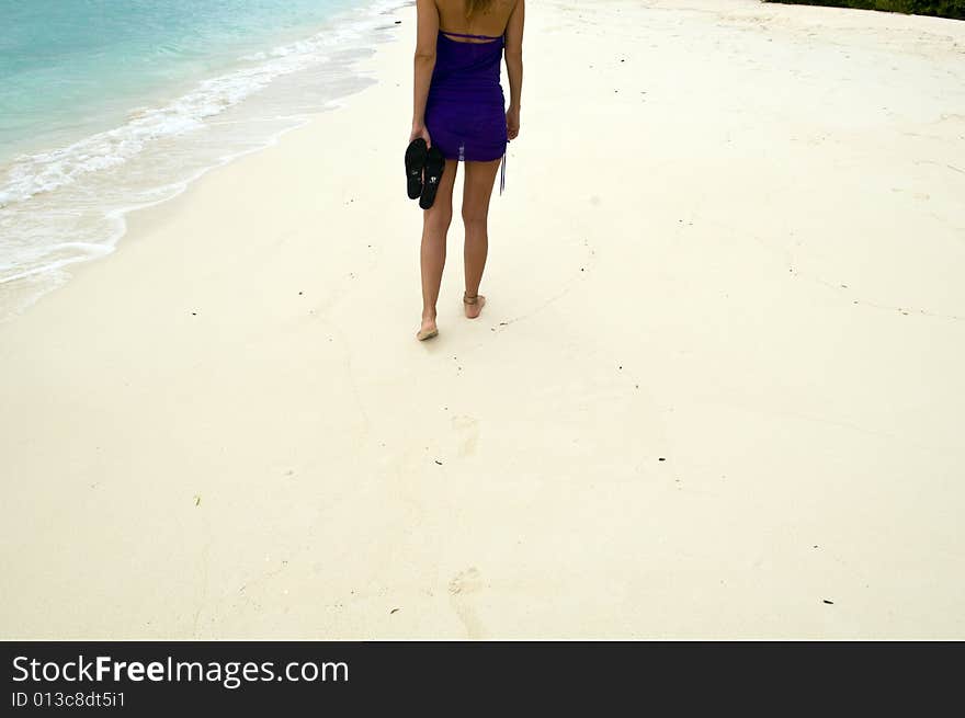 Woman walking on the sandy beach