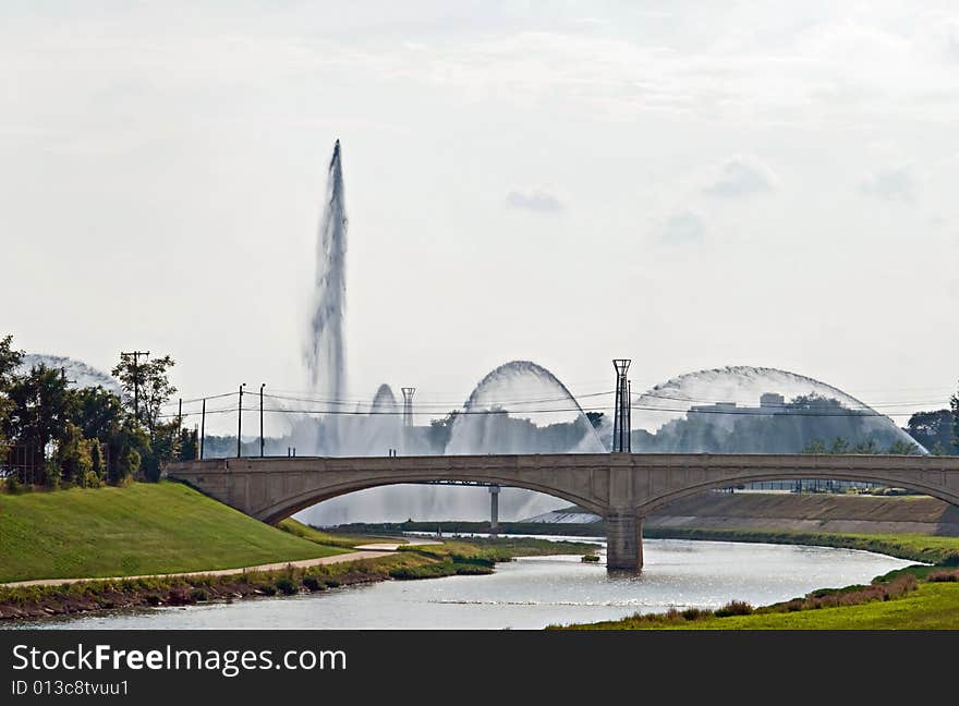 Fountains spaying by bridge over the river. Fountains spaying by bridge over the river.