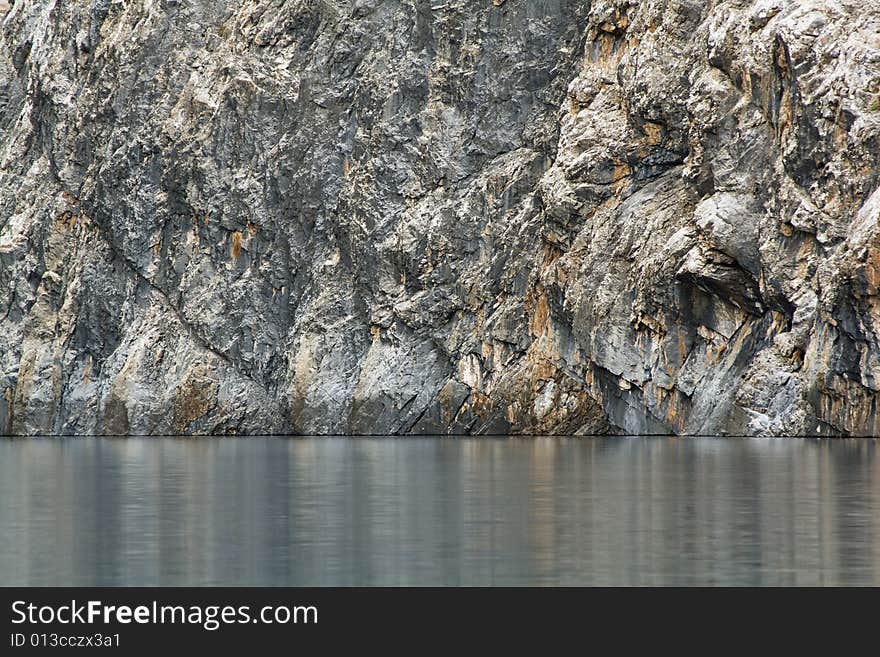 Huge vertical rock wall above the lake