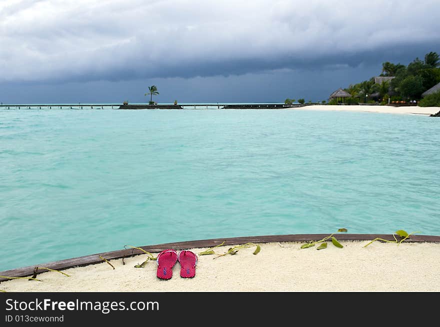 Red thongs on the sandy beach