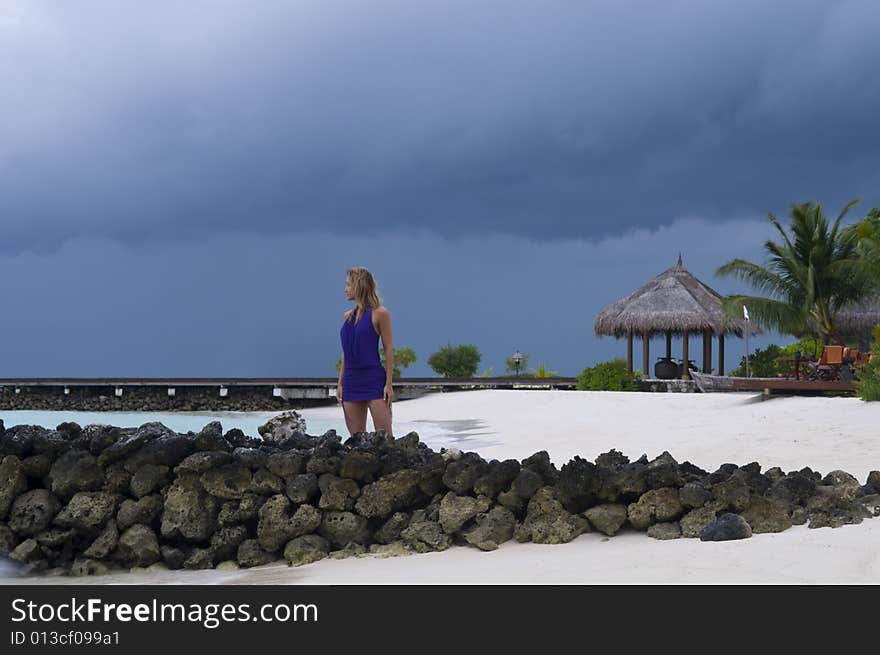 Sexy woman watching indian ocean in Maldives at sunset