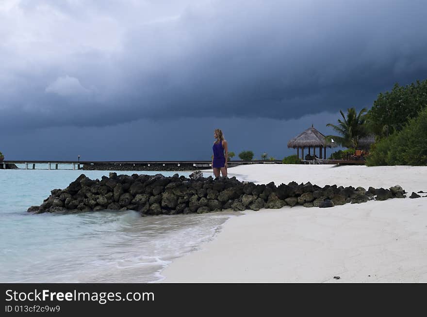 Sexy woman watching indian ocean in Maldives at sunset