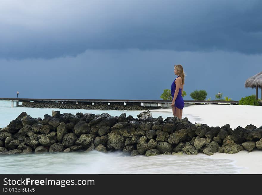 Sexy woman watching indian ocean in Maldives at sunset