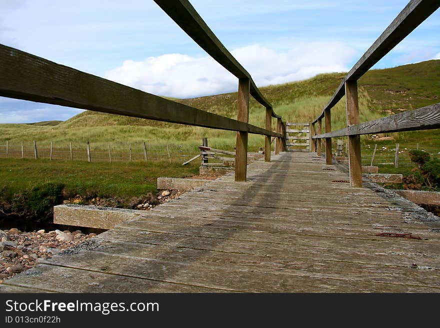 An old wooden footbridge gated at the end.