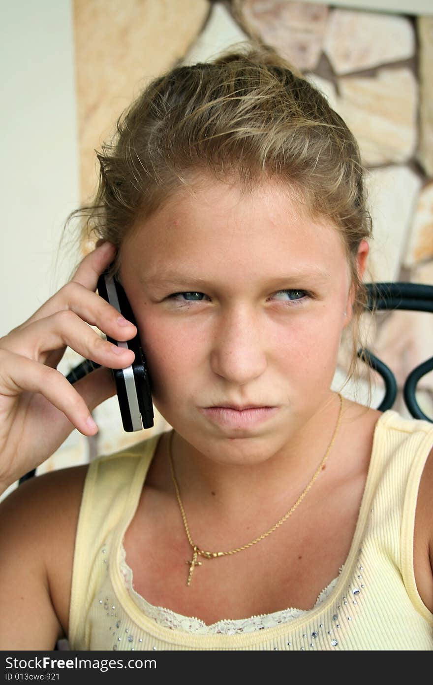 Photo of a 12 year old beautiful girl talking on her cell phone to her friends. Photo of a 12 year old beautiful girl talking on her cell phone to her friends