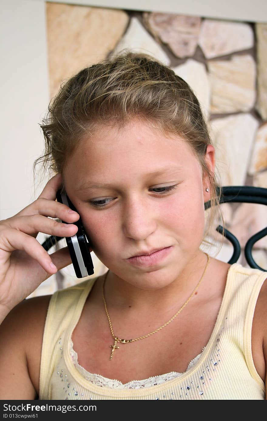 Photo of a 12 year old beautiful girl talking on her cell phone to her friends. Photo of a 12 year old beautiful girl talking on her cell phone to her friends