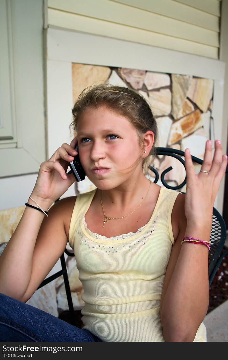 Photo of a 12 year old beautiful girl talking on her cell phone to her friends. Photo of a 12 year old beautiful girl talking on her cell phone to her friends