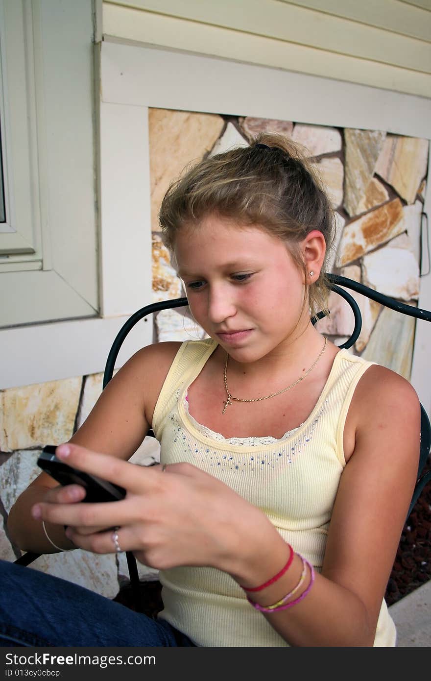 Photo of a 12 year old beautiful girl text messaging on cell phone. Photo of a 12 year old beautiful girl text messaging on cell phone