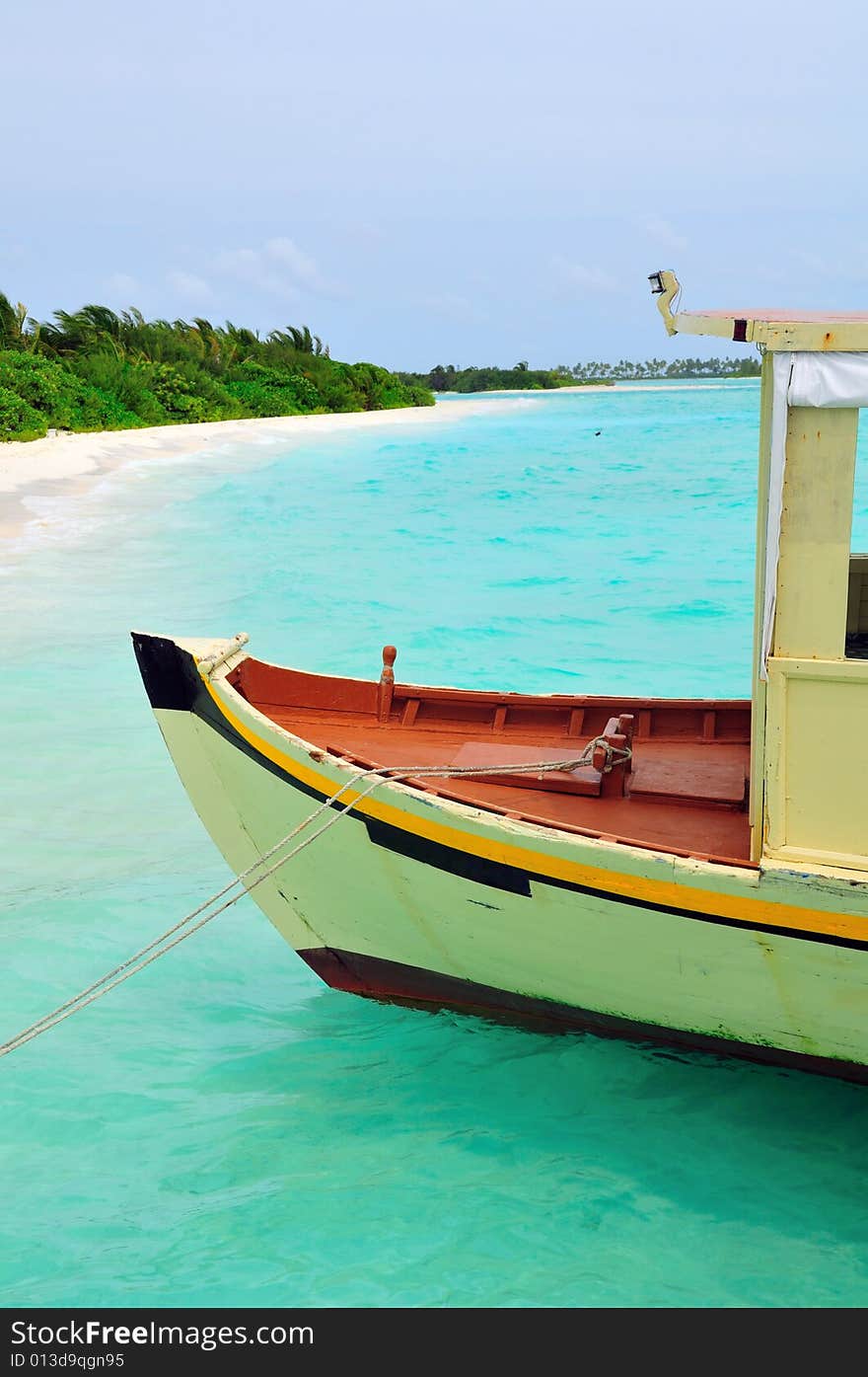 Old traditional boat anchored on a sandy beach in Maldives