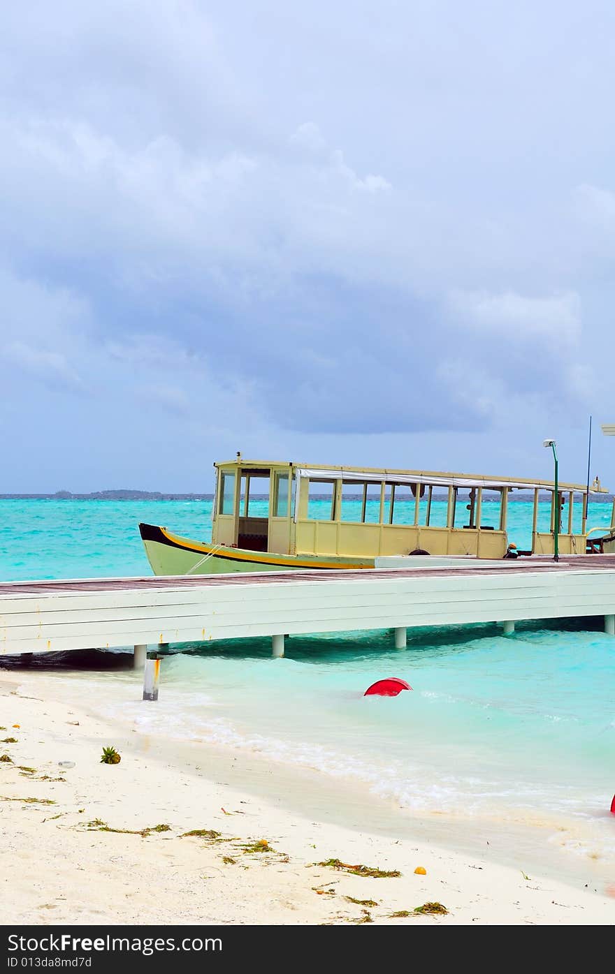 Old traditional boat anchored on a sandy beach in Maldives
