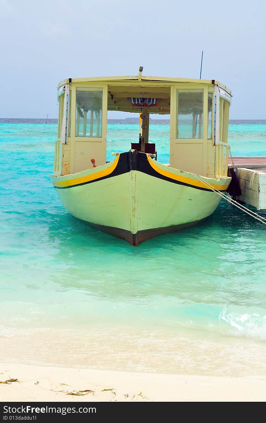 Old traditional boat anchored on a sandy beach in Maldives