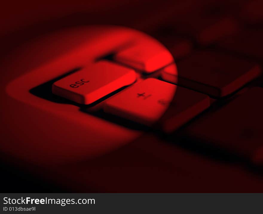 Red lighting effect applied to escape key on laptop keyboard