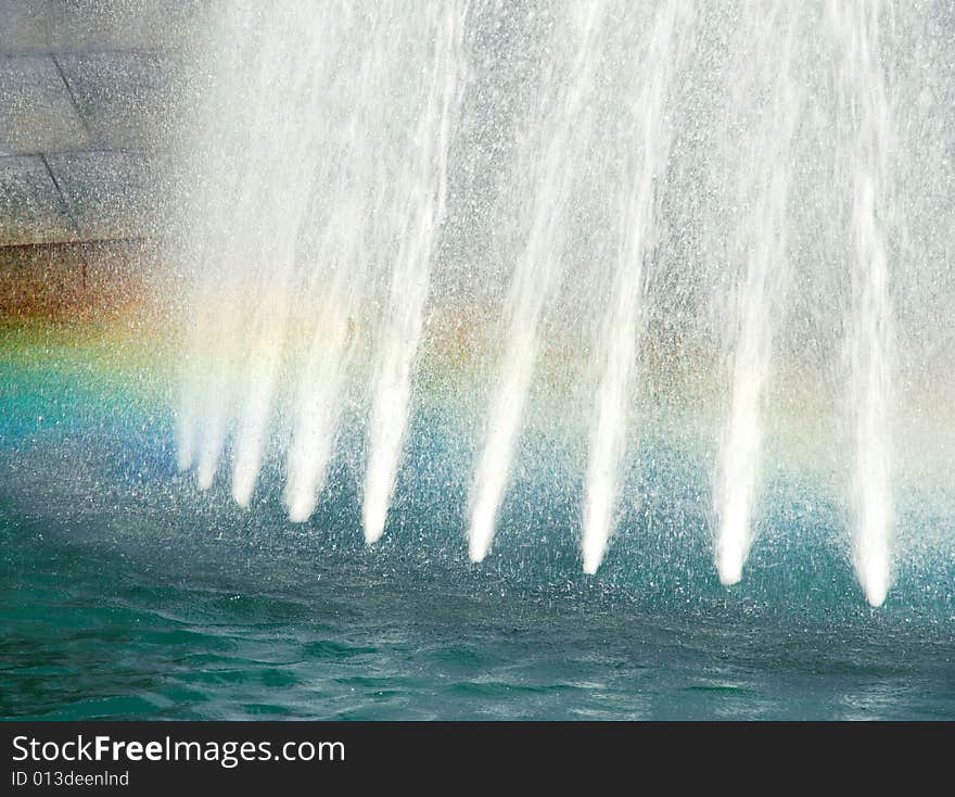 Water white streams in blue fountain with rainbow