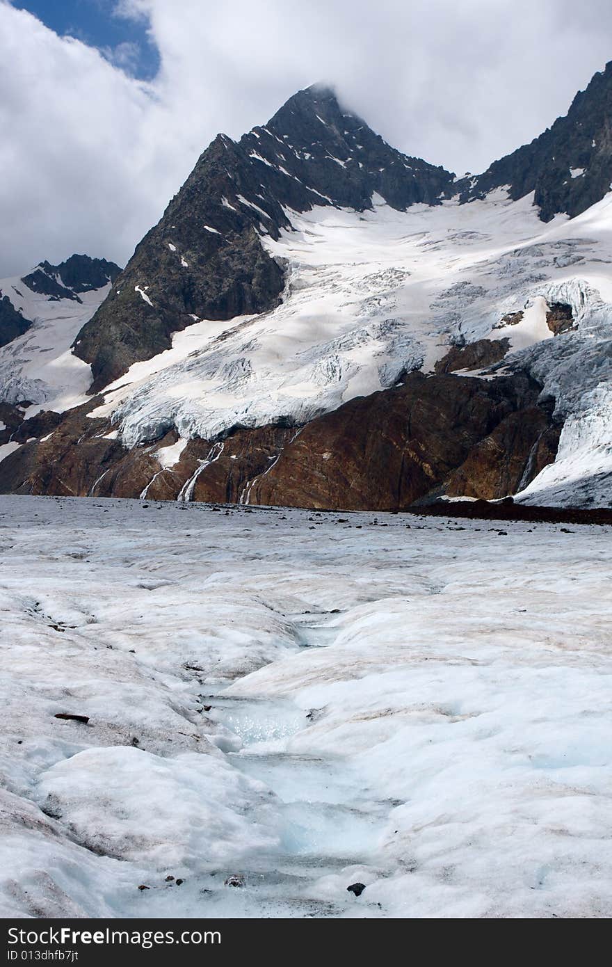 Spring on glacier in high Caucasus mountains