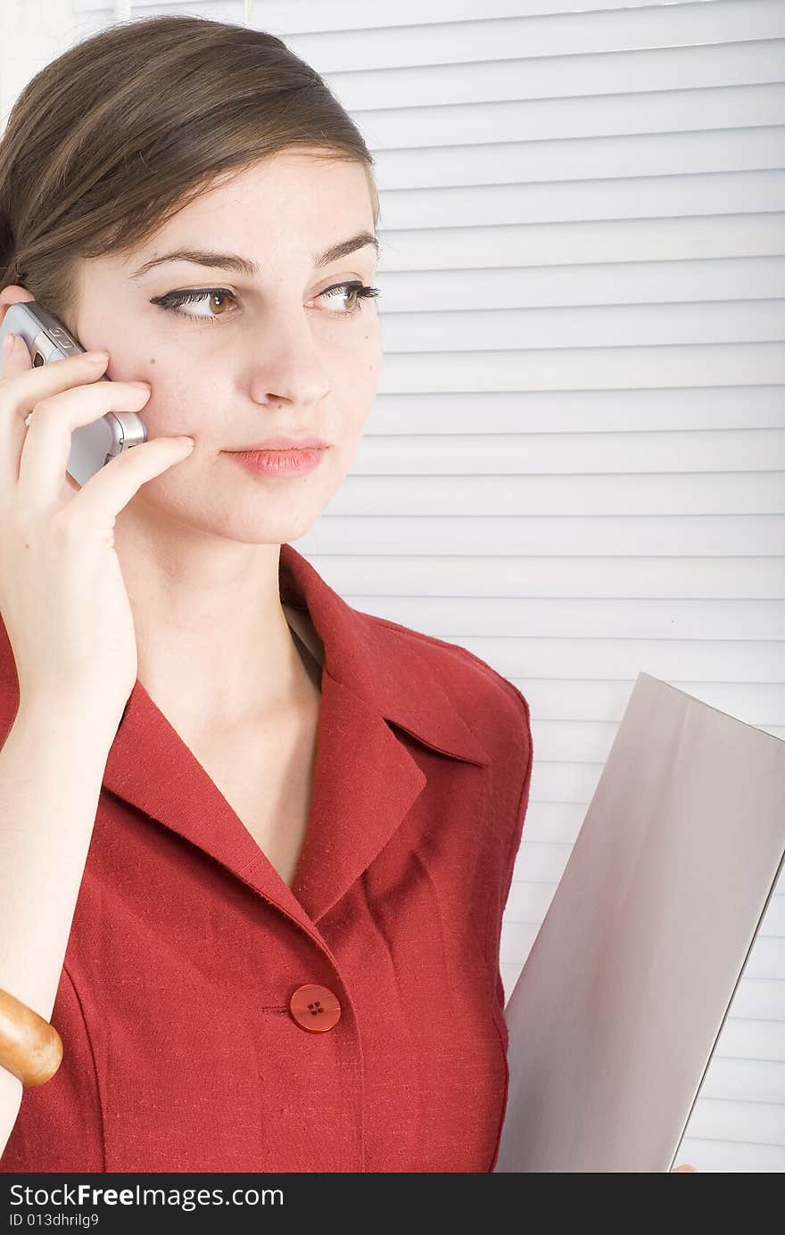 Office woman talking on her cell phone. Office woman talking on her cell phone