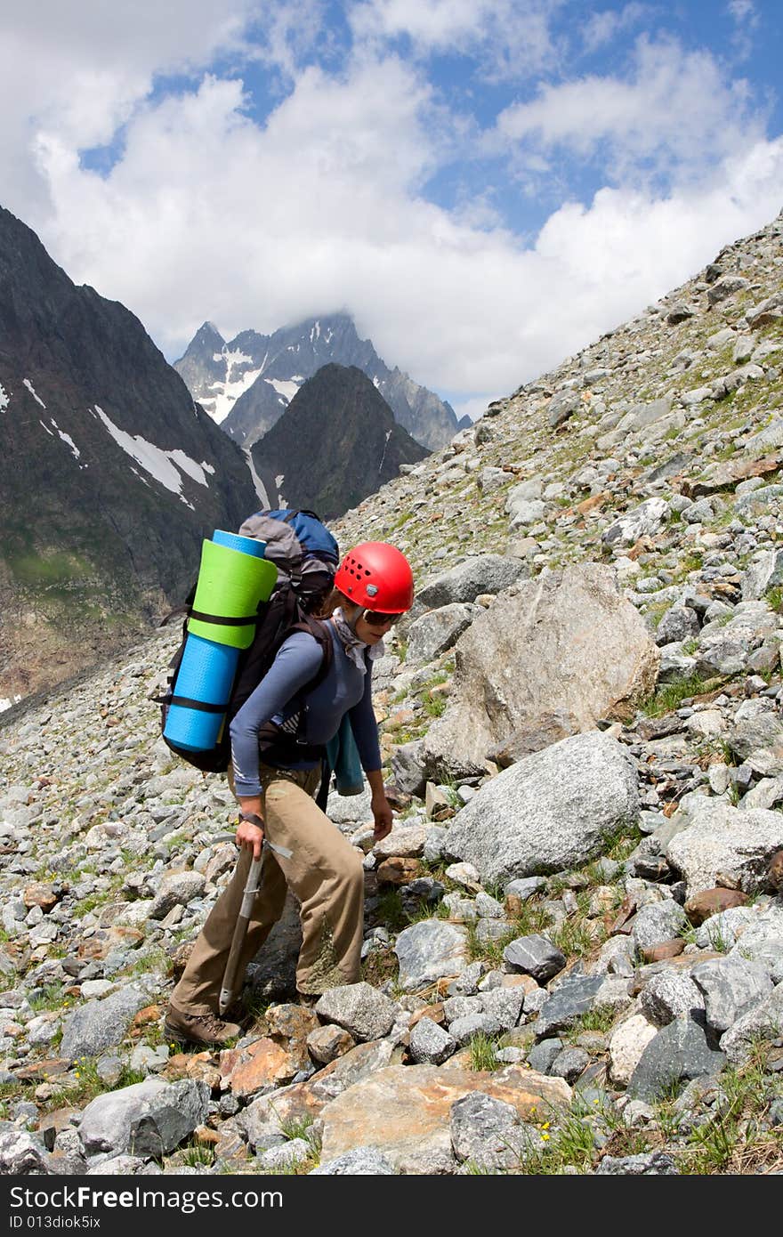 Gril backpacker traveling on talus in mountains