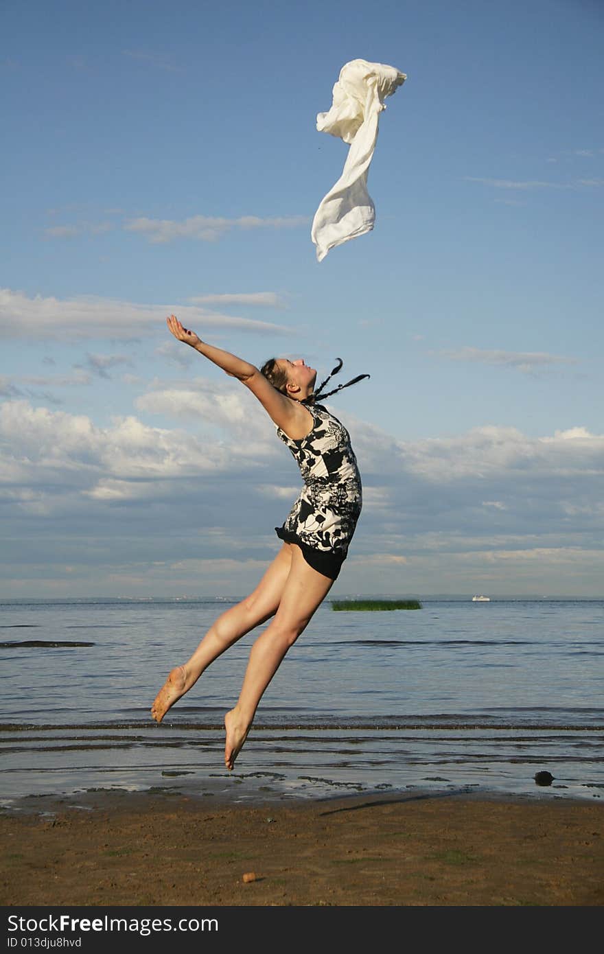 Woman jumping on the beach with white textile. Woman jumping on the beach with white textile