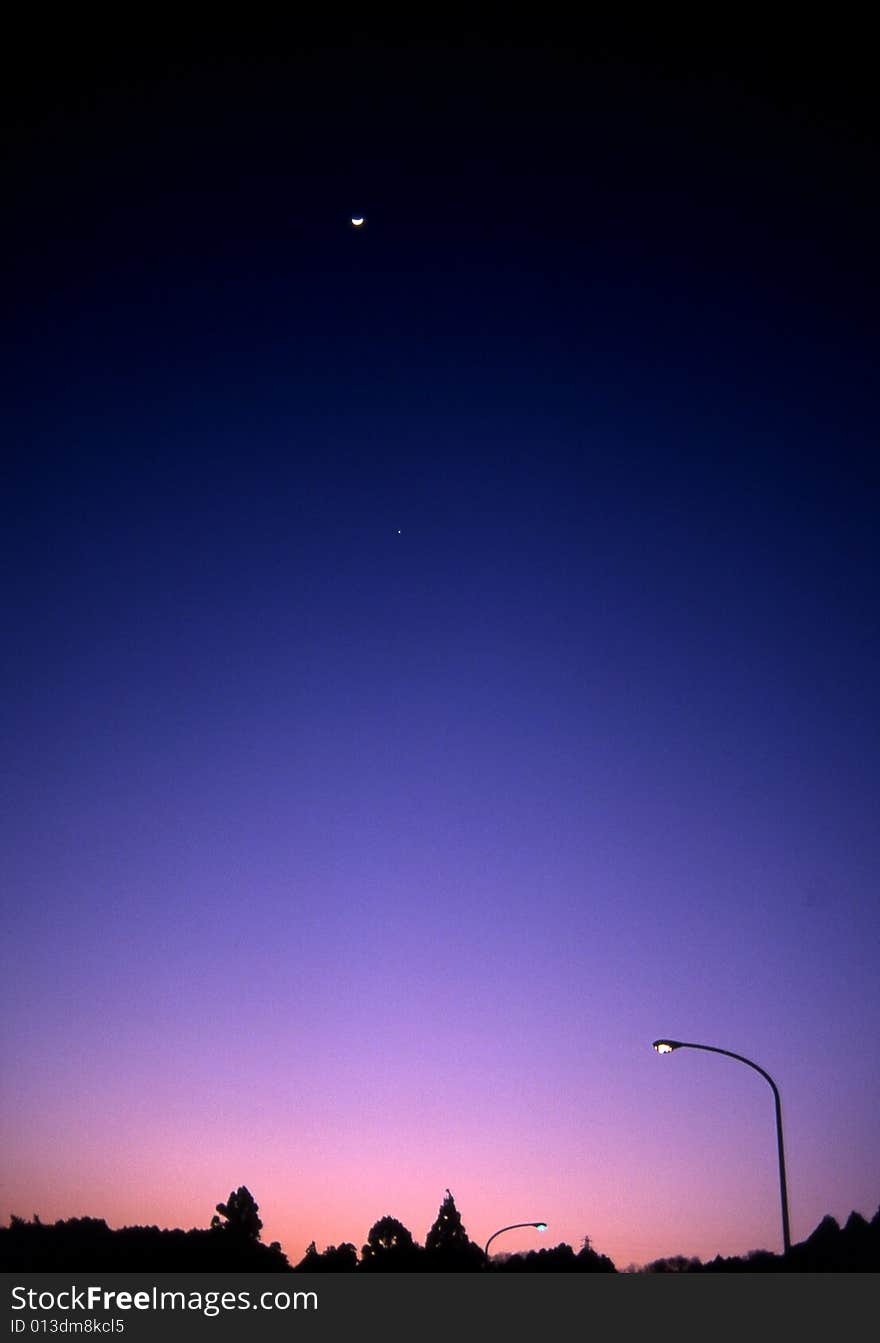 Twilight in suburban Aichi, Japan with a speck of a moon in the upper sky. Twilight in suburban Aichi, Japan with a speck of a moon in the upper sky