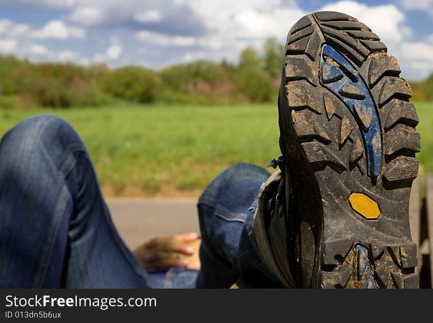 Hiker taking a rest on a summer-day.Focus on bottom of hiking-boots