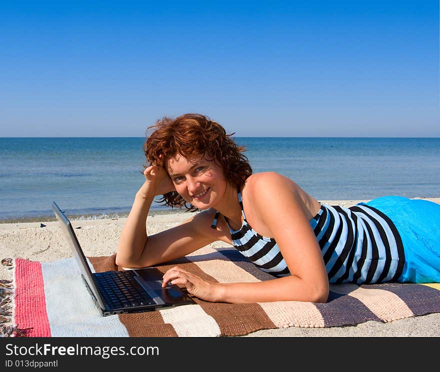 Woman with laptop computer at sea beach. Woman with laptop computer at sea beach