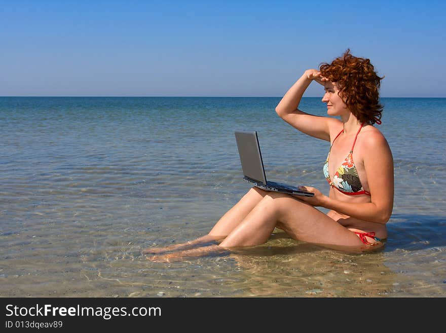 Woman with laptop computer sitting in the sea. Woman with laptop computer sitting in the sea
