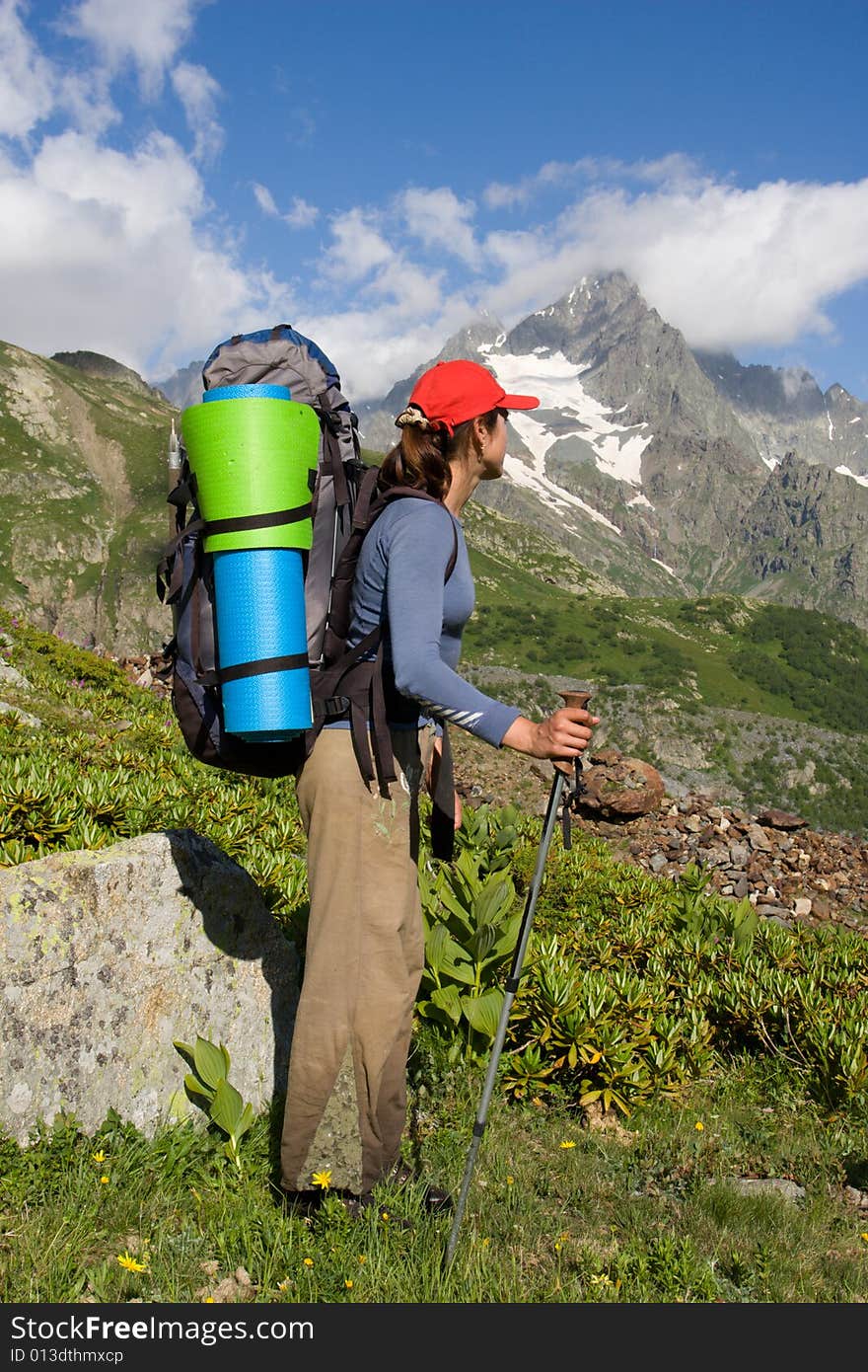 Backpacker girl looking to a high mountain. Backpacker girl looking to a high mountain