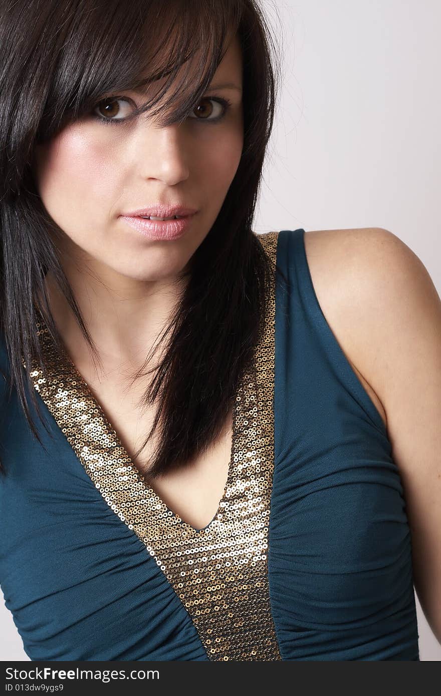 Portrait of a beautiful young brunette woman wearing a green fashionable top. Portrait of a beautiful young brunette woman wearing a green fashionable top