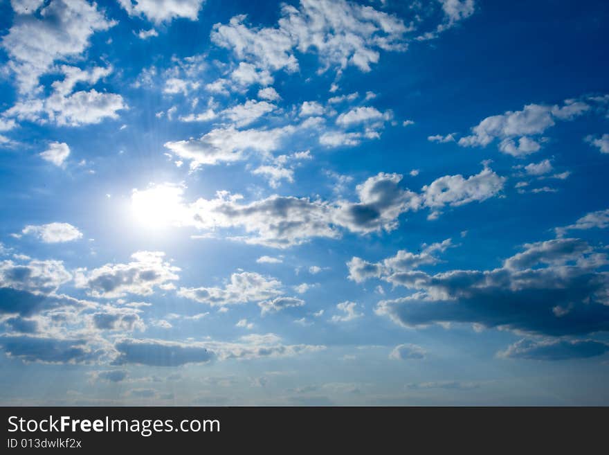 Cloudscape with sun in blue sky