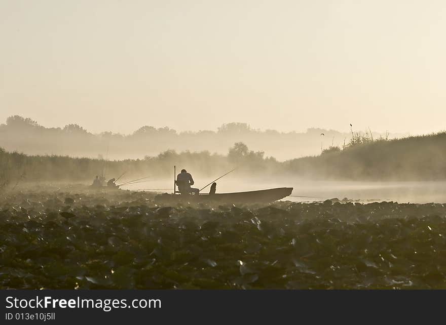 Fishermen fishing on lake with morning