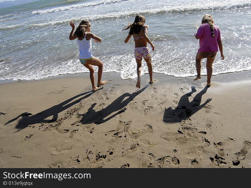 Three little girls playing and jumping on the beach. Three little girls playing and jumping on the beach