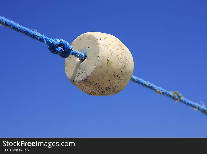 Buoys float and knot on the rope against the background of the blue sky. Buoys float and knot on the rope against the background of the blue sky.