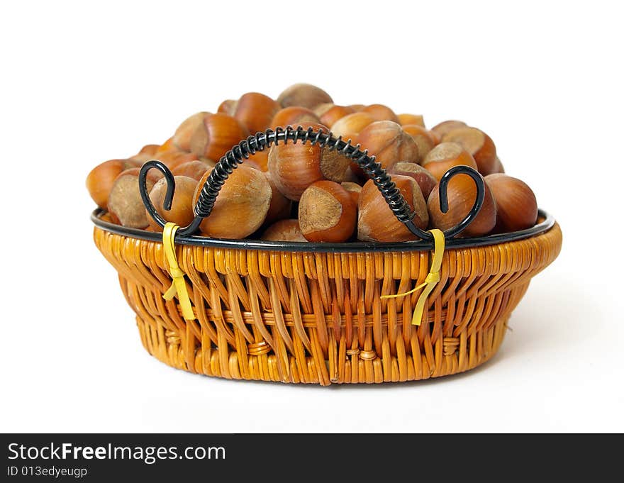 Wood nuts in a basket isolated on white