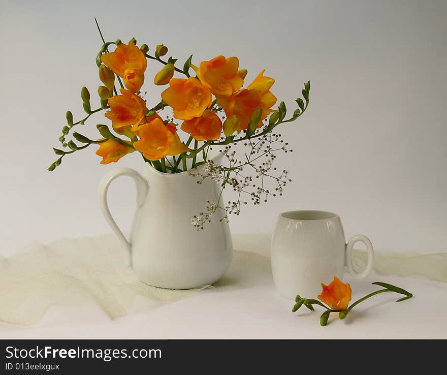 A cup yellow freesia fragrances flowers in white jug