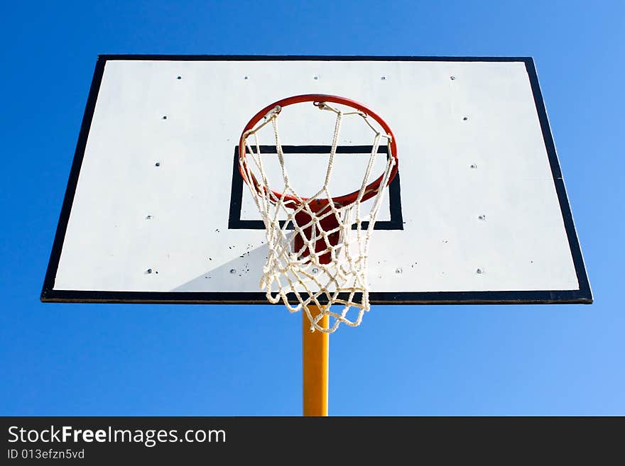 Basketball hoop with blue sky in background
