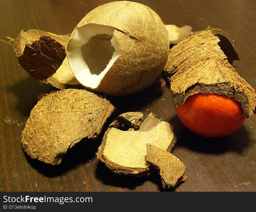 Broken coconut and a tangerine covered by shell