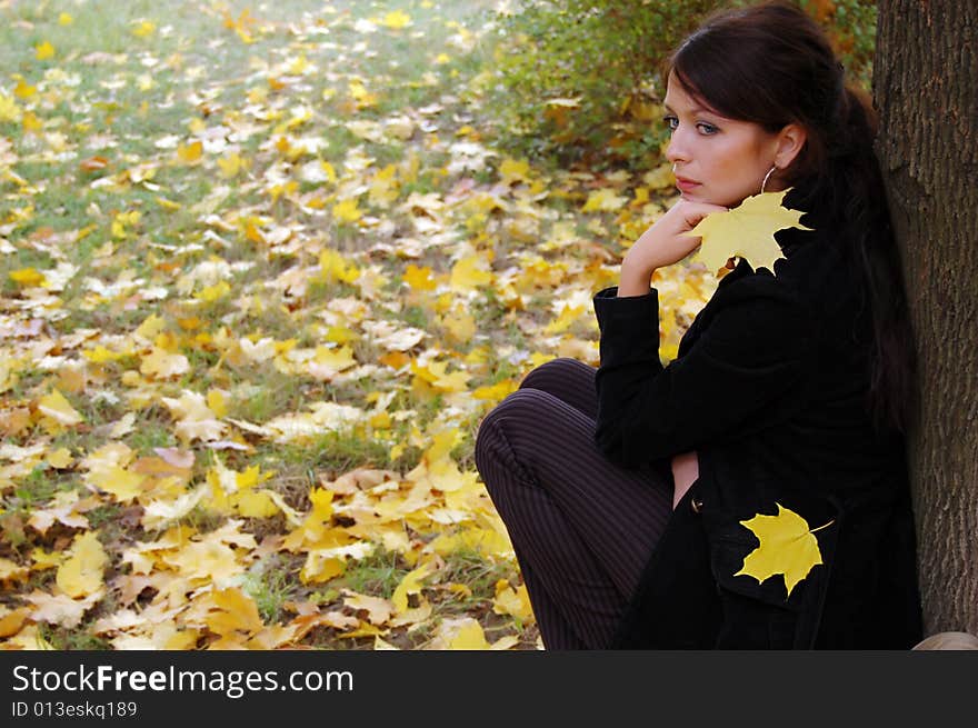 Autumn girl portrait outdoors with yellow leaf