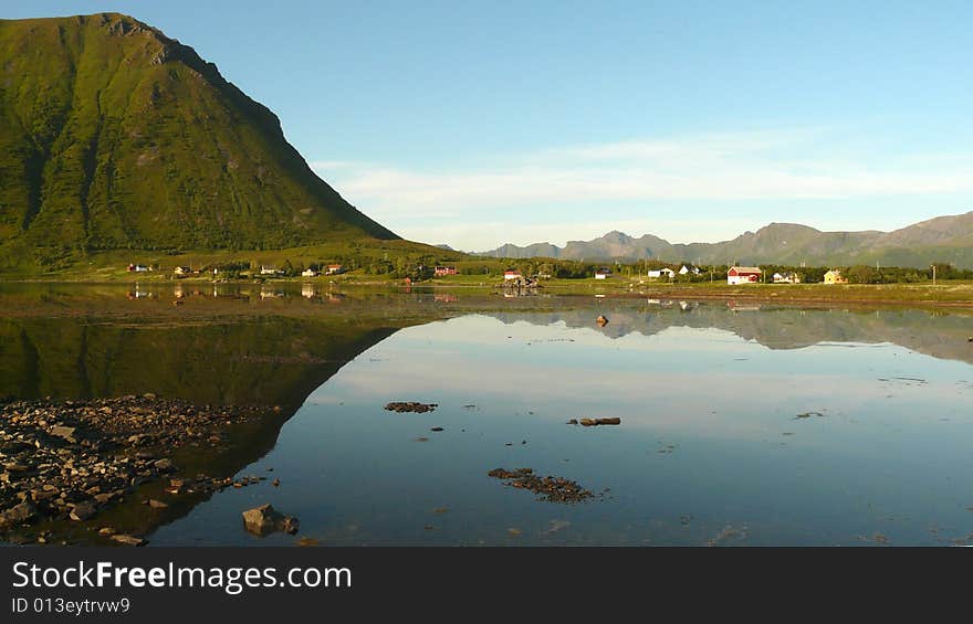 Small village  mirroring at midnight, Lofoten islands, Norwegian arctic circle. Small village  mirroring at midnight, Lofoten islands, Norwegian arctic circle