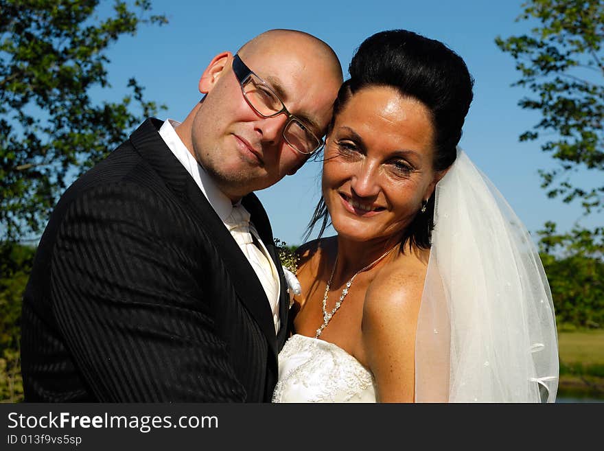 A very happy wedding couple standing close together.