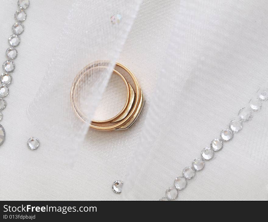 Closeup of wedding rings on a white veil