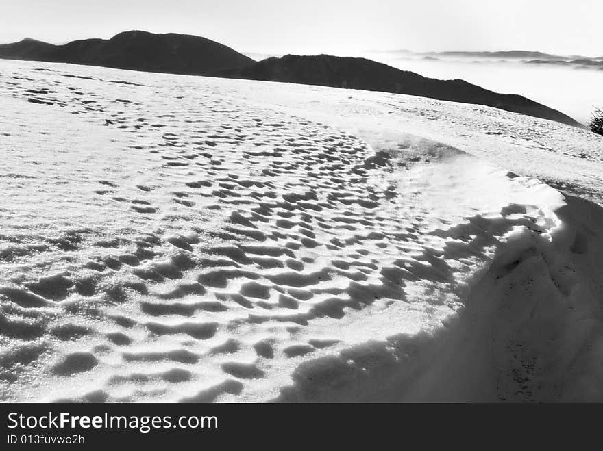 The large flat snow area in the mountains with interesting snow texture in balack and white. The large flat snow area in the mountains with interesting snow texture in balack and white