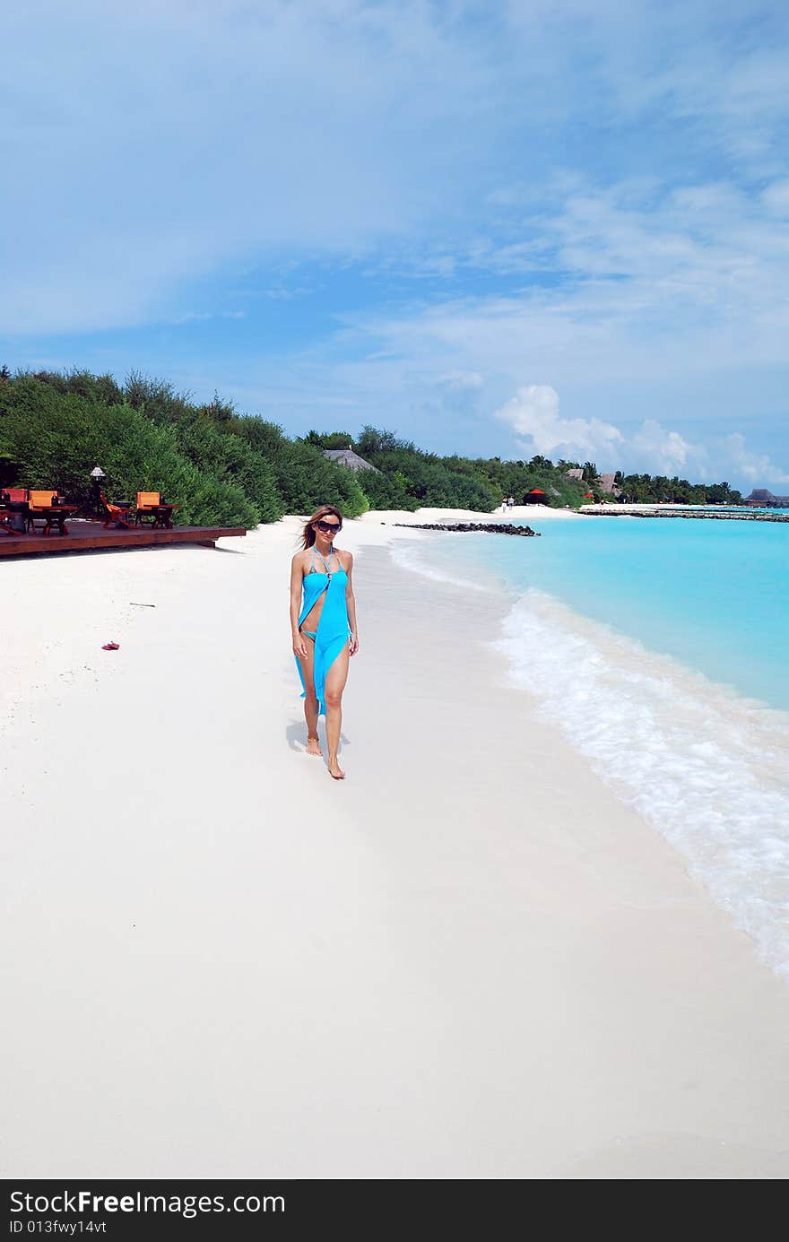 Happy woman walking on the tropical beach