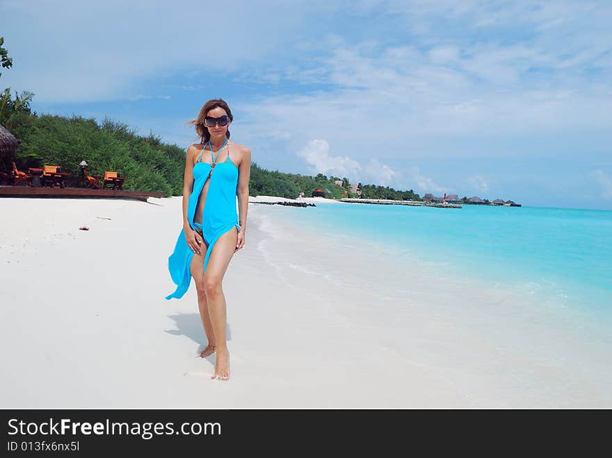 Happy woman walking on the tropical beach