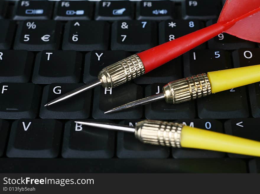 Darts on a laptop computer keyboard. Darts on a laptop computer keyboard