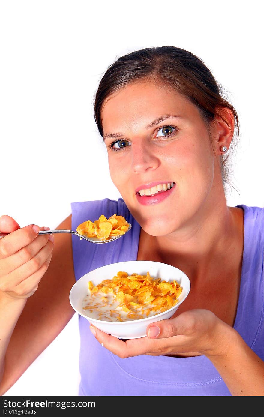 A young woman enjoys her crunchy cornflakes. Isolated over white. ** Note: Slight blurriness best at smaller sizes. A young woman enjoys her crunchy cornflakes. Isolated over white. ** Note: Slight blurriness best at smaller sizes