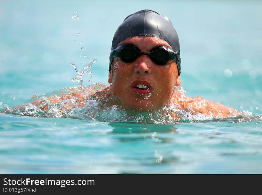 Young man swimming in a lake with professional gear on. Ideal shot for summer / vacation.