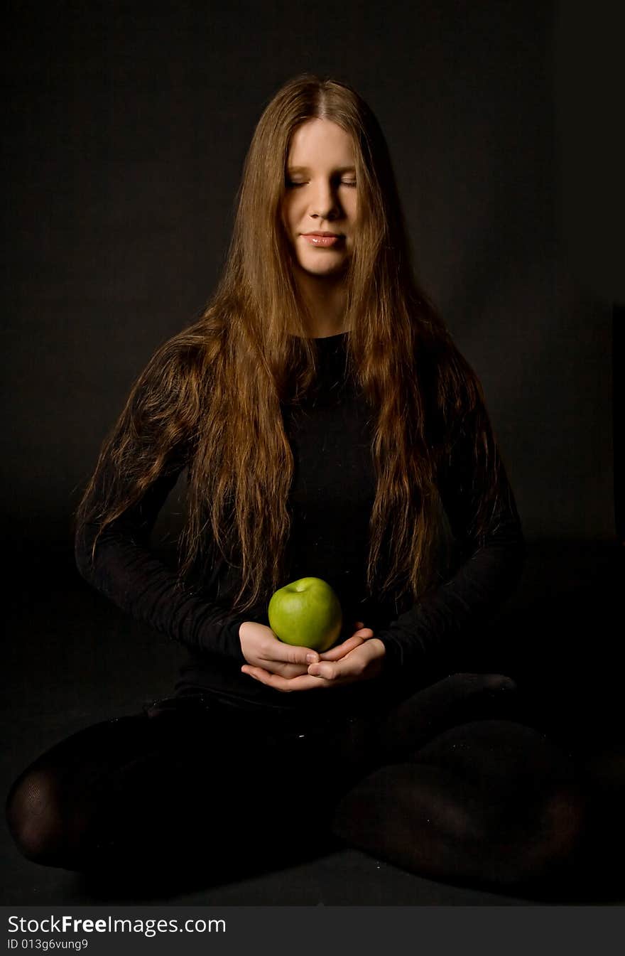 The portrait of a woman with a green apple in her hands. The portrait of a woman with a green apple in her hands