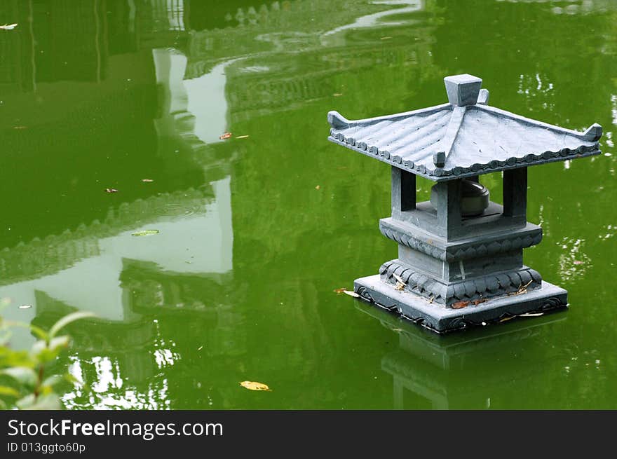 Oriental garden lamp on the lake with reflections. Oriental garden lamp on the lake with reflections