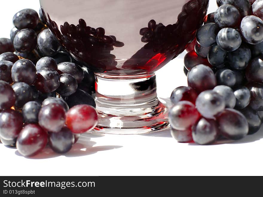 Grape juice in the glass and ripe grapes